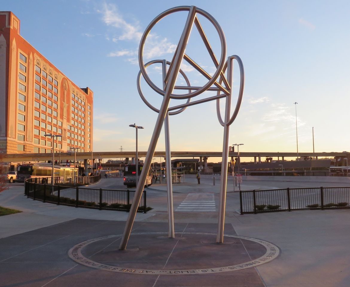 Wheels is a public art sculpture by artists Bill Baker and Claudia Cuesta located at the Civic Center Transit Center. The sculpture is a symbol of the movement and life of people, trains, buses, and the city. The sculpture is ringed with a poem by T.S. Eliot.