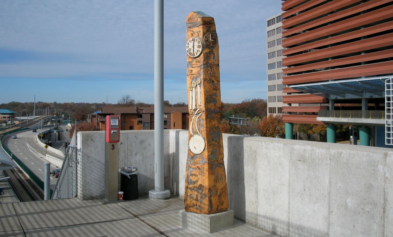 Grandfather Clocks is a public installation of three ceramic sculptures by Carol Fleming located at the Clayton MetroLink station. Each is reminiscent of old railroad clocks and encourage people to pause during their commute.